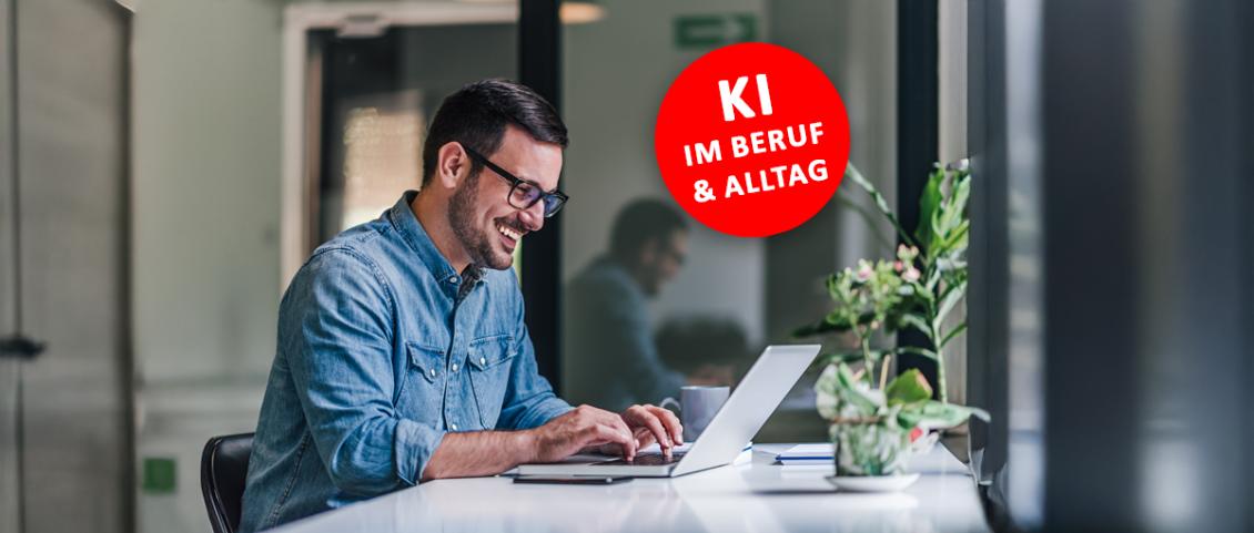 Ein Mann mit schwarzen Haaren sitzt an einem Office-schreibtisch, lächelnd vor seinem Laptop, ein roter Runder Button mit 'KI Im Beruf und Alltag' ist rechts neben ihm platziert.