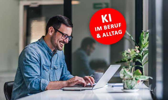 Ein Mann mit schwarzen Haaren sitzt an einem Office-schreibtisch, lächelnd vor seinem Laptop, ein roter Runder Button mit 'KI Im Beruf und Alltag' ist rechts neben ihm platziert.